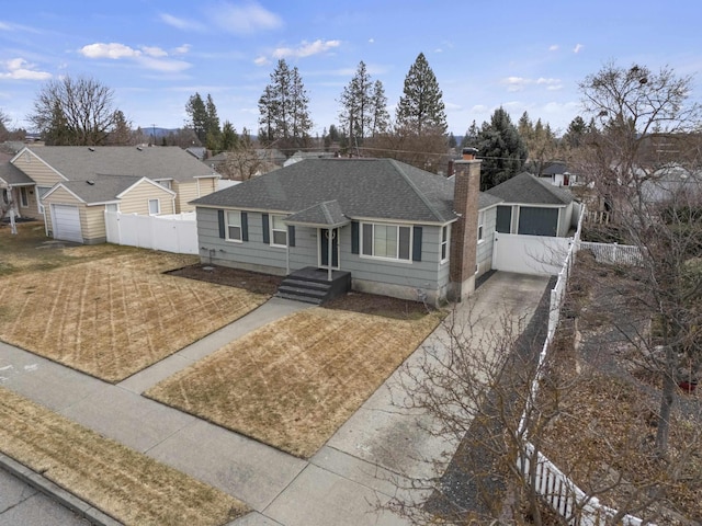 view of front of property with fence, a chimney, a shingled roof, a garage, and a residential view