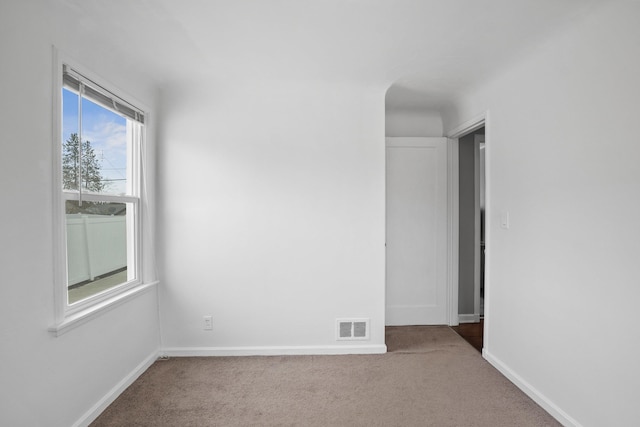 spare room with visible vents, baseboards, and carpet