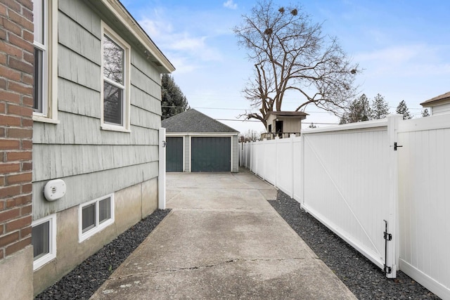 exterior space with a detached garage, an outdoor structure, and fence