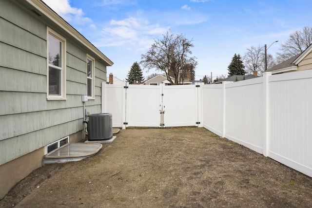 view of yard featuring a gate, cooling unit, and fence private yard