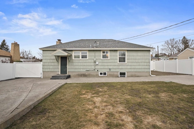 rear view of house featuring fence, a patio area, and a lawn