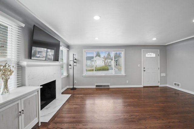 unfurnished living room featuring visible vents, dark wood-type flooring, and a fireplace