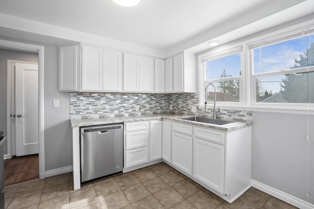 kitchen with a sink, backsplash, dishwasher, and white cabinets