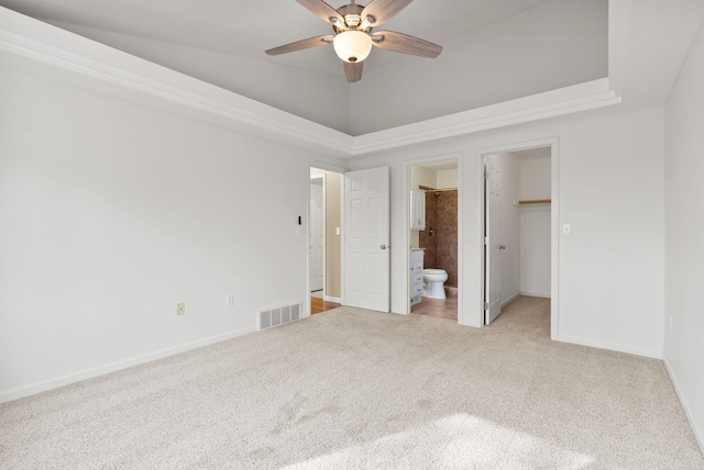 unfurnished bedroom with a spacious closet, visible vents, baseboards, carpet floors, and ensuite bath