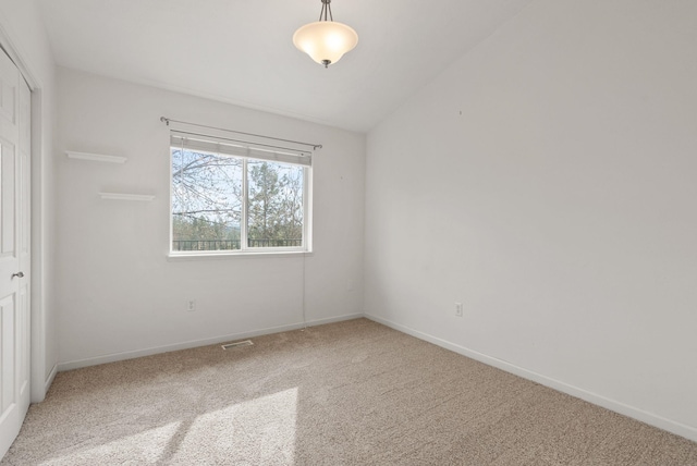 unfurnished bedroom featuring a closet, baseboards, lofted ceiling, and carpet flooring