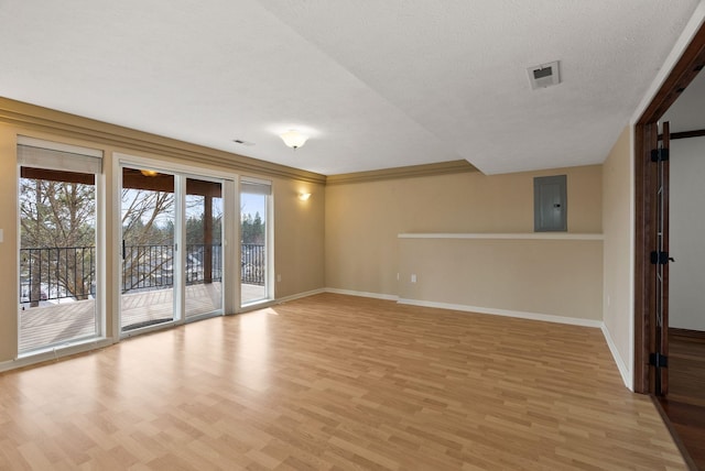 unfurnished room featuring electric panel, light wood-style floors, baseboards, and a textured ceiling