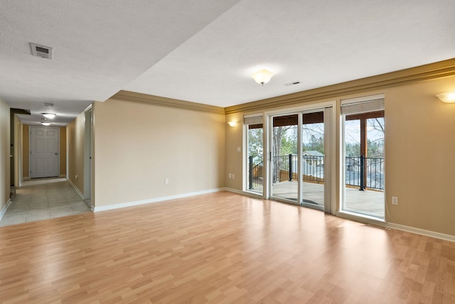 spare room featuring visible vents, baseboards, and light wood-style flooring