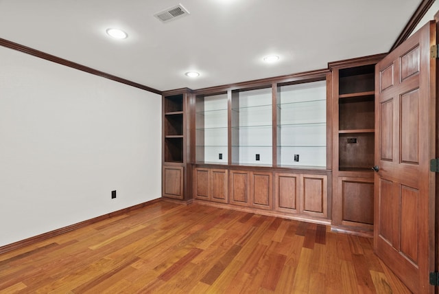 spare room featuring light wood-type flooring, visible vents, ornamental molding, recessed lighting, and baseboards