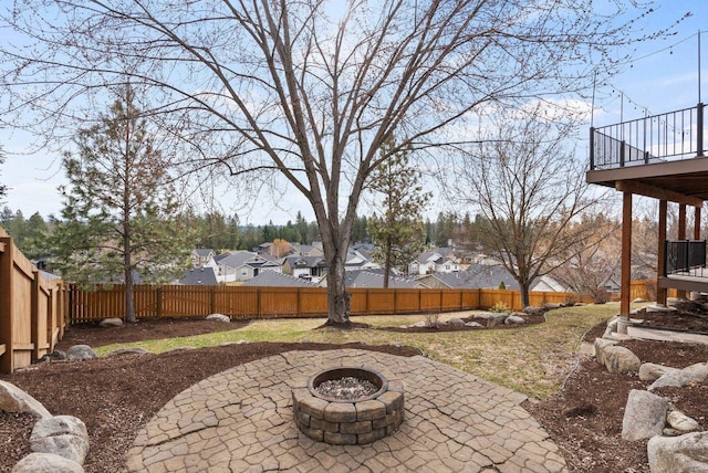 view of yard with a fenced backyard, a residential view, an outdoor fire pit, and a patio