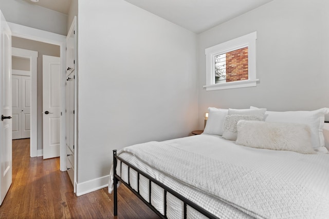 bedroom with baseboards and wood finished floors