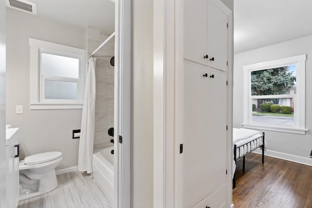 bathroom with visible vents, toilet, wood finished floors, baseboards, and vanity