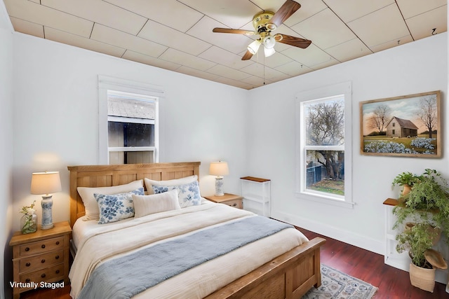 bedroom featuring ceiling fan, baseboards, and wood finished floors