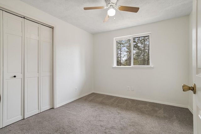 unfurnished bedroom featuring a ceiling fan, baseboards, carpet floors, a closet, and a textured ceiling