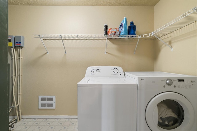 clothes washing area with laundry area, separate washer and dryer, baseboards, and light floors