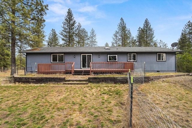 rear view of house with a deck, fence, a lawn, and crawl space