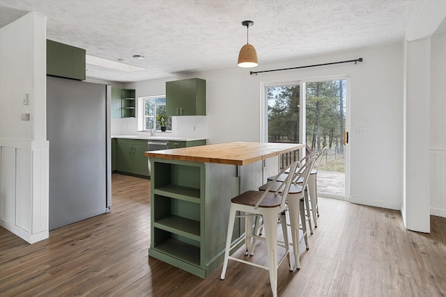 kitchen with wooden counters, light wood-style flooring, open shelves, and green cabinetry