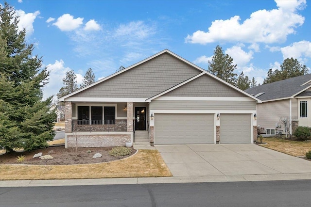 view of front facade with brick siding, covered porch, driveway, and a garage