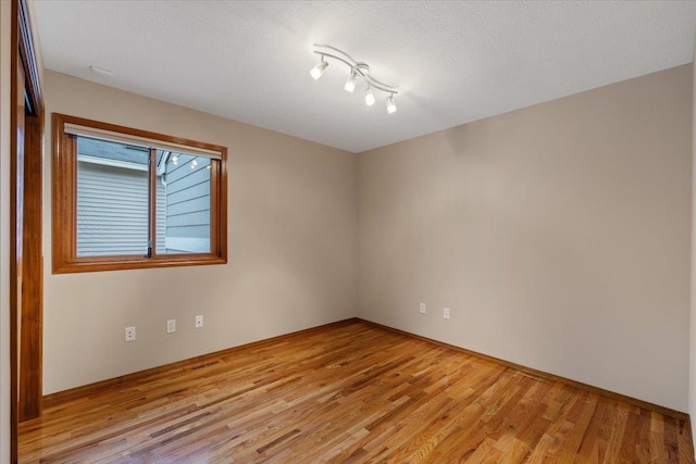 spare room with light wood-style flooring and a textured ceiling