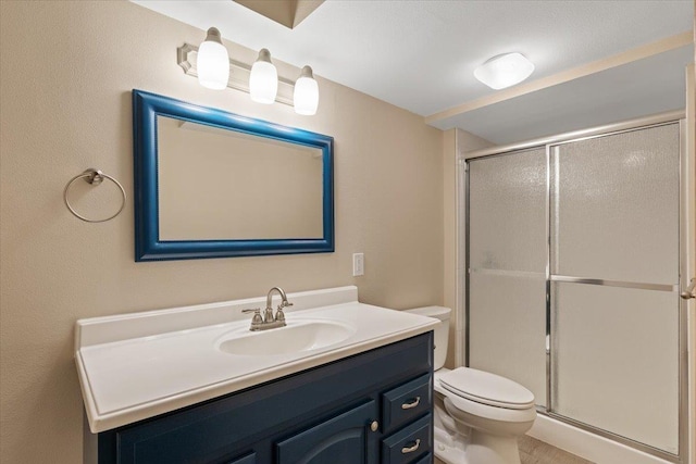 bathroom featuring toilet, a stall shower, and vanity