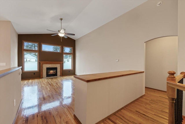 unfurnished living room featuring a wealth of natural light, light wood-style flooring, and vaulted ceiling