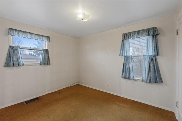 spare room with visible vents, carpet flooring, and baseboards