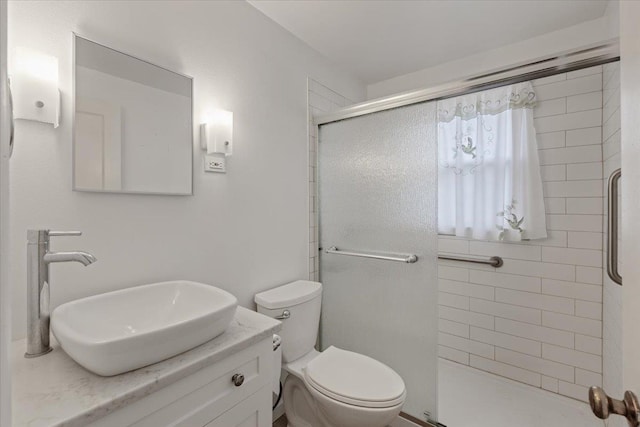 bathroom with toilet, a stall shower, and vanity