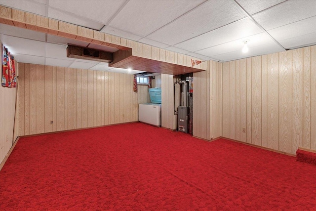 finished below grade area featuring wooden walls, a paneled ceiling, and carpet floors