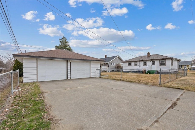 view of front of home featuring a fenced front yard, a detached garage, and an outbuilding