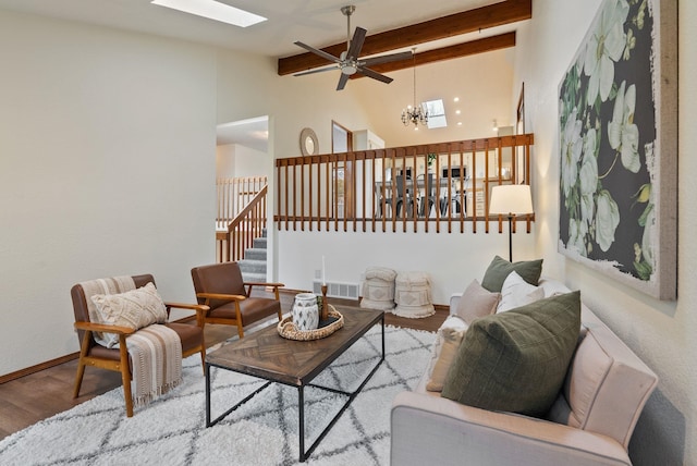 living room featuring wood finished floors, visible vents, a skylight, stairs, and beamed ceiling