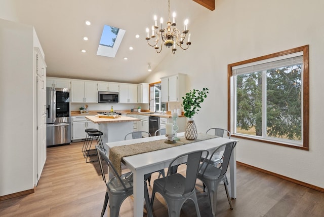 dining space with recessed lighting, baseboards, light wood-style floors, and high vaulted ceiling