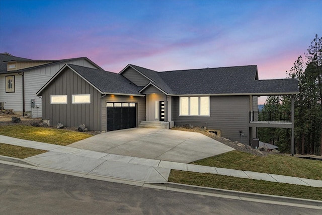 view of front of house featuring an attached garage, board and batten siding, driveway, and a shingled roof