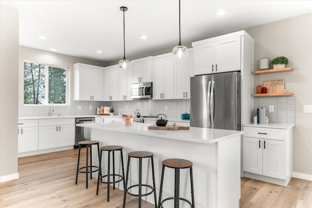 kitchen featuring white cabinetry, a kitchen breakfast bar, and stainless steel appliances