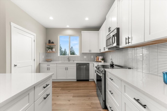 kitchen featuring a sink, stainless steel appliances, backsplash, and light countertops