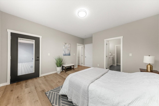 bedroom featuring ensuite bathroom, light wood-type flooring, and baseboards