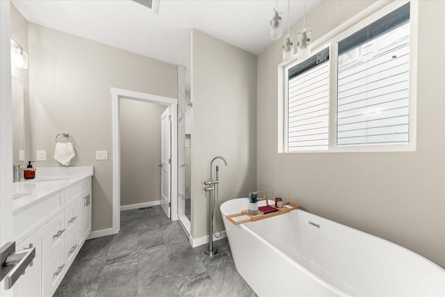 full bath featuring baseboards, a freestanding bath, and vanity