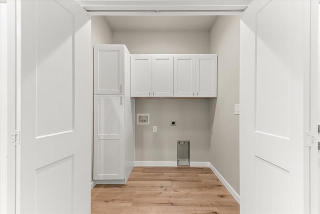 clothes washing area with electric dryer hookup, washer hookup, cabinet space, light wood-style floors, and baseboards