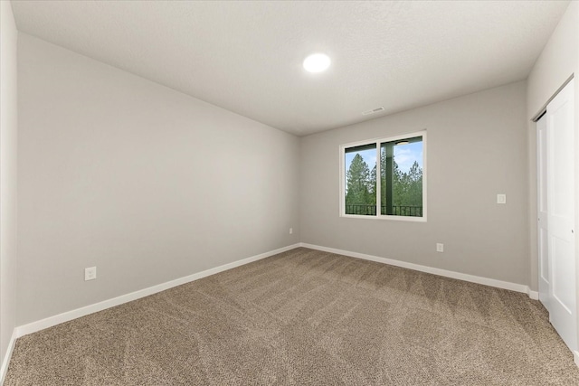 unfurnished bedroom with visible vents, baseboards, a textured ceiling, and carpet flooring