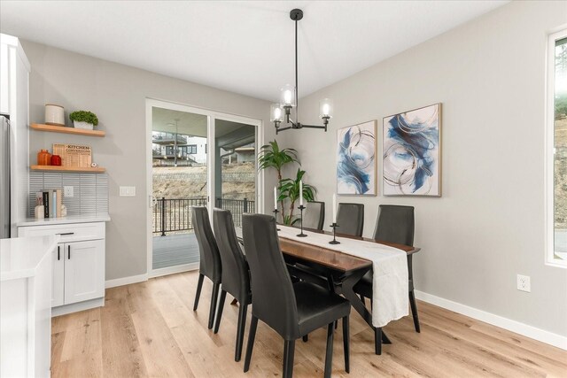 dining room with light wood-style flooring, plenty of natural light, and a chandelier