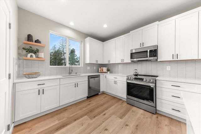 kitchen featuring a sink, stainless steel appliances, open shelves, and light countertops