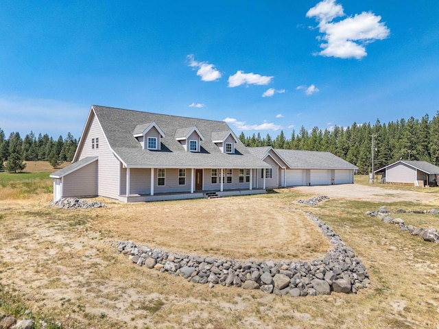 view of front of home featuring a detached garage, a front yard, roof with shingles, covered porch, and driveway