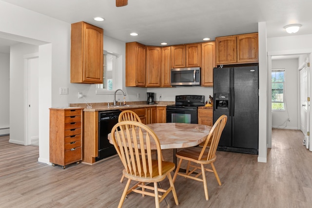 kitchen with baseboards, light wood-style flooring, recessed lighting, a sink, and black appliances