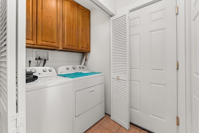 laundry room with light tile patterned floors, cabinet space, and separate washer and dryer