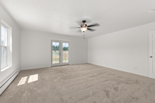 empty room featuring a baseboard heating unit, ceiling fan, baseboards, carpet, and french doors