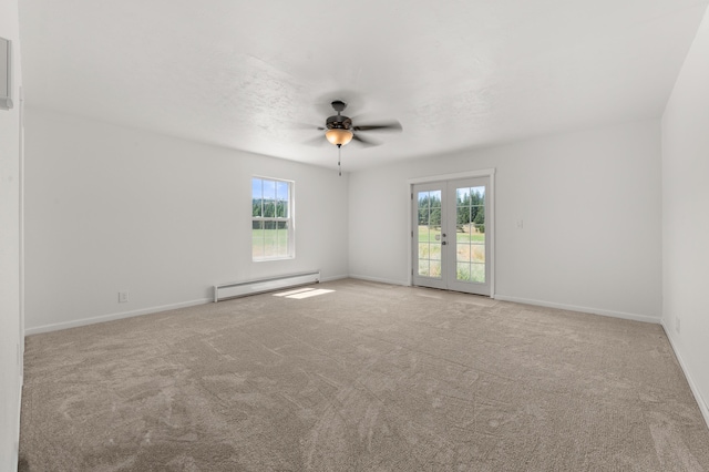 empty room featuring baseboard heating, a healthy amount of sunlight, and carpet