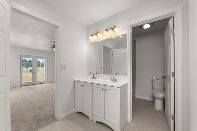 full bathroom with double vanity, toilet, french doors, and a sink