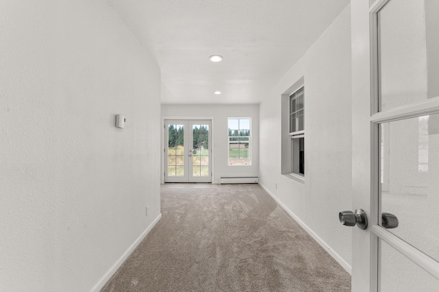 corridor featuring baseboards, french doors, carpet flooring, a textured wall, and baseboard heating