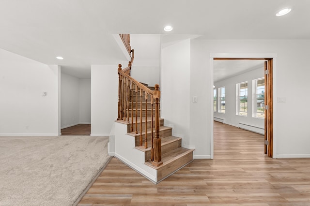 stairway featuring recessed lighting, a baseboard heating unit, and wood finished floors