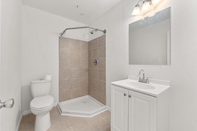 full bath with tiled shower, toilet, vanity, and tile patterned flooring