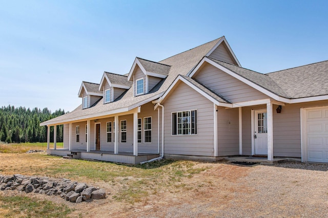 view of front of house featuring covered porch and a shingled roof