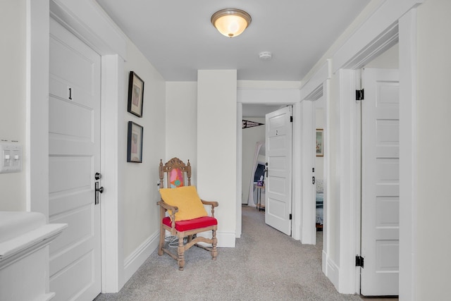 hallway featuring carpet flooring and baseboards